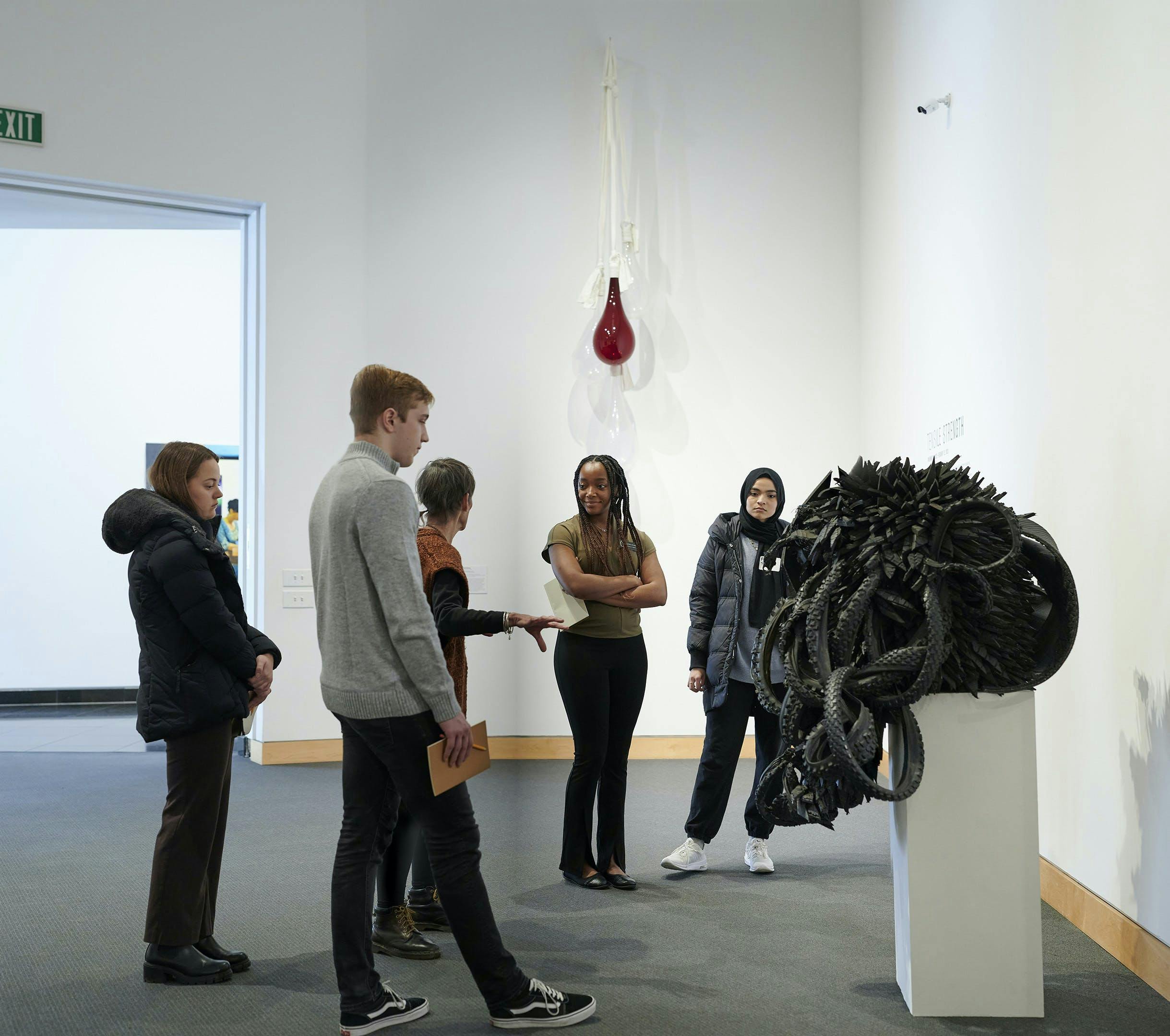 A group of people talking about a sculpture in a Kemper Museum gallery