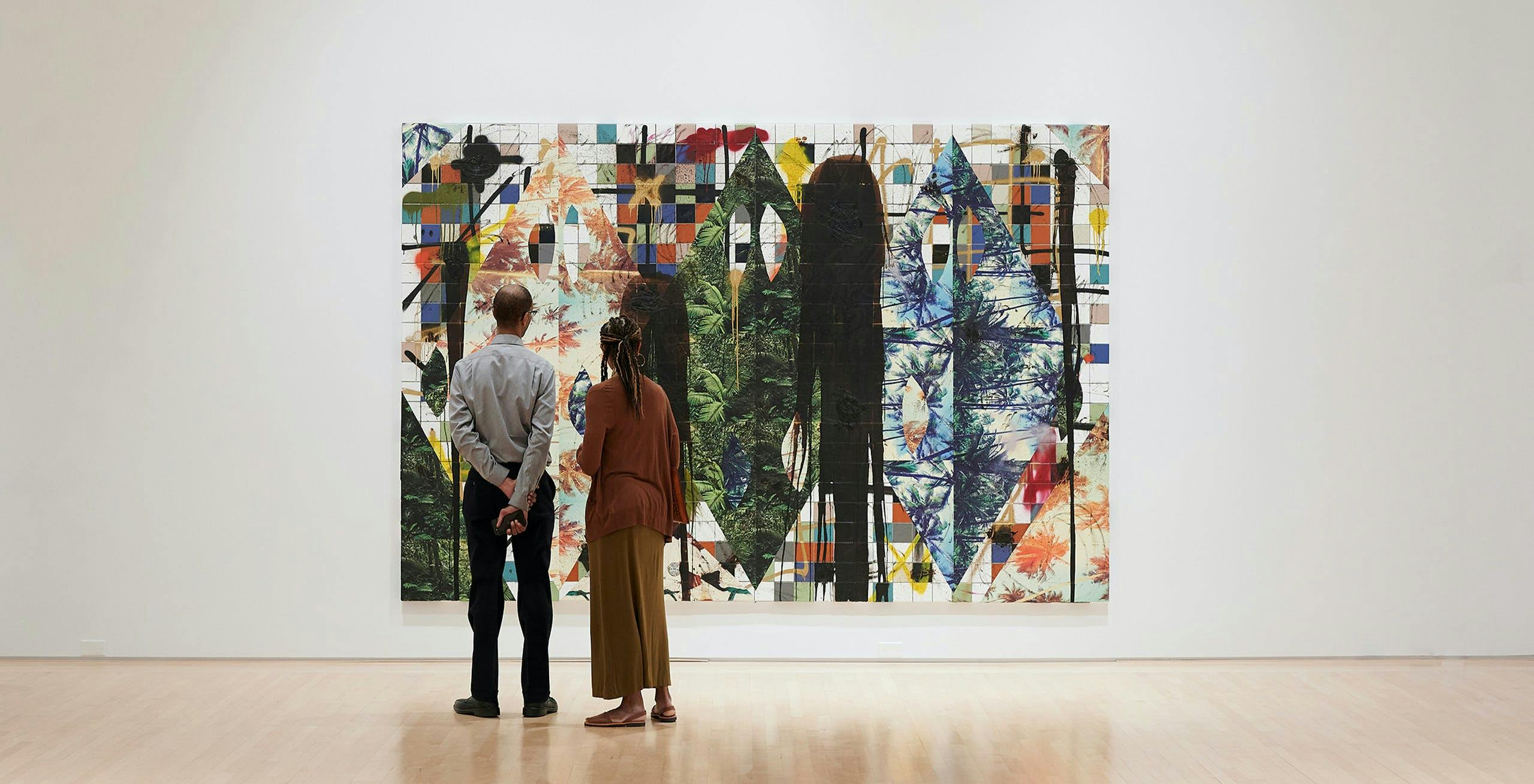 A couple standing in front of an art piece
